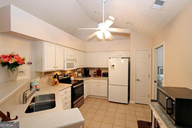 kitchen featuring a sink, backsplash, white cabinetry, white appliances, and vaulted ceiling