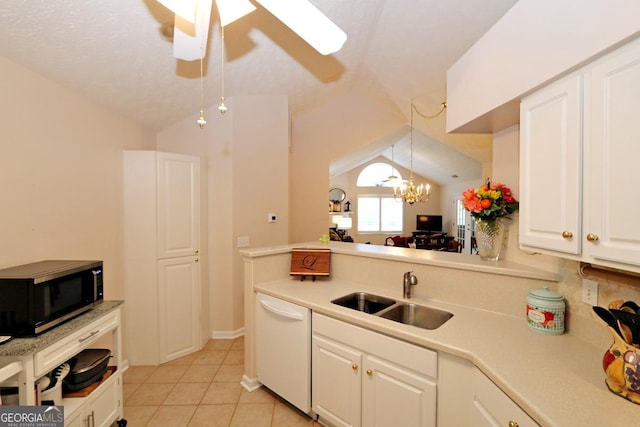 kitchen with a sink, stainless steel microwave, white dishwasher, light countertops, and lofted ceiling