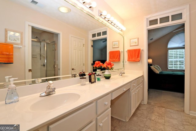 ensuite bathroom with double vanity, visible vents, a shower stall, and a sink