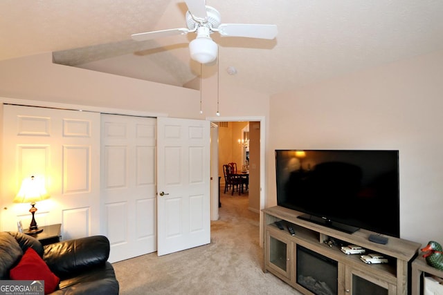 living area featuring light carpet, ceiling fan, and vaulted ceiling