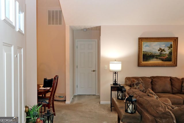 living area featuring visible vents, light carpet, and baseboards