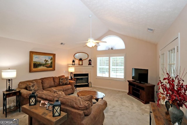 living room with visible vents, light colored carpet, vaulted ceiling, and a tile fireplace