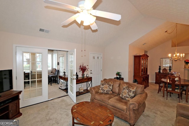 living area featuring visible vents, lofted ceiling, french doors, light carpet, and ceiling fan with notable chandelier