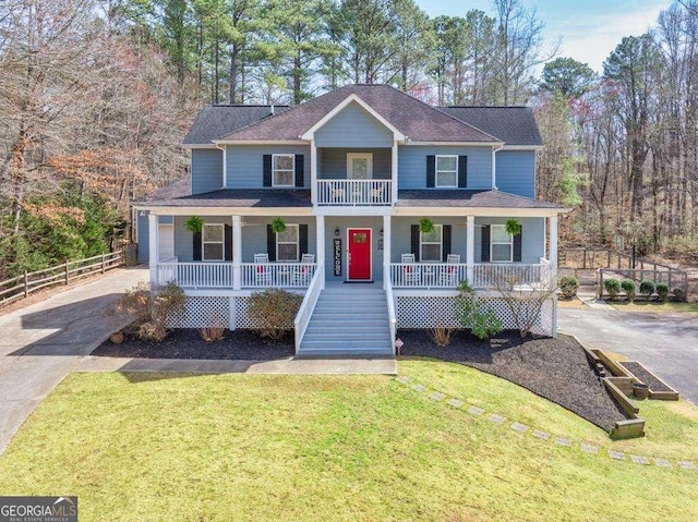 view of front facade featuring a front yard, fence, driveway, covered porch, and a shingled roof