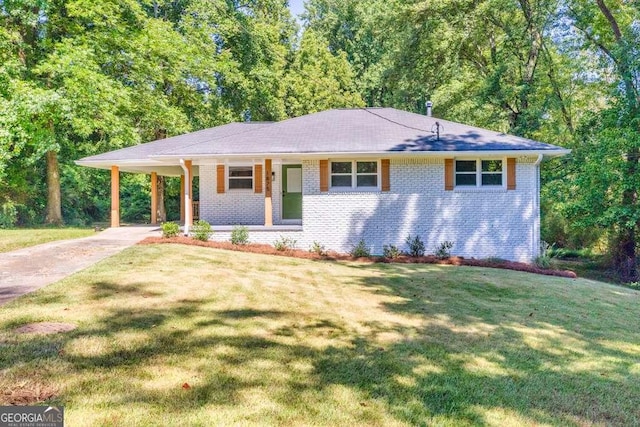 single story home featuring a carport, driveway, a front lawn, and brick siding