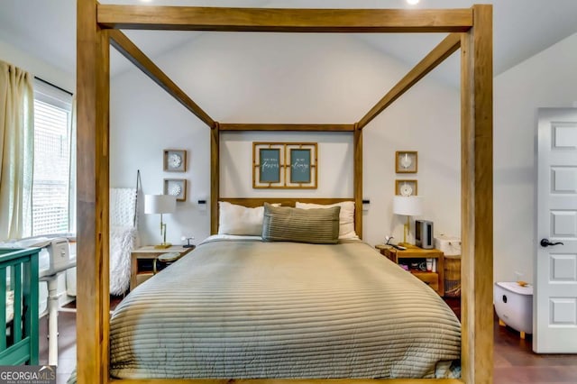 bedroom with wood finished floors and vaulted ceiling