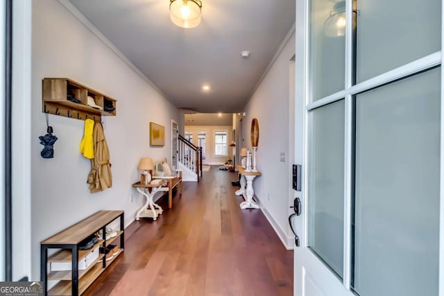 hallway with stairs, wood finished floors, and baseboards