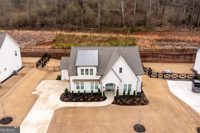 view of front of home with a shingled roof and fence