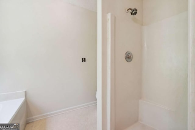 full bath featuring a shower and baseboards