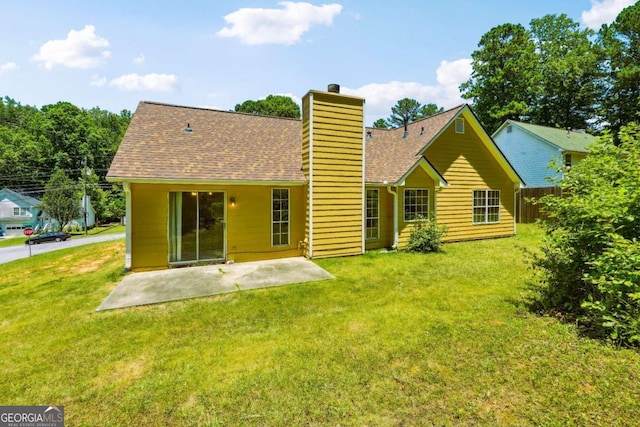 rear view of house featuring a lawn, fence, roof with shingles, a chimney, and a patio area