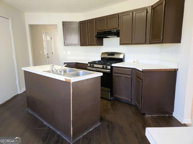 kitchen with gas range, dark wood-type flooring, under cabinet range hood, and a sink