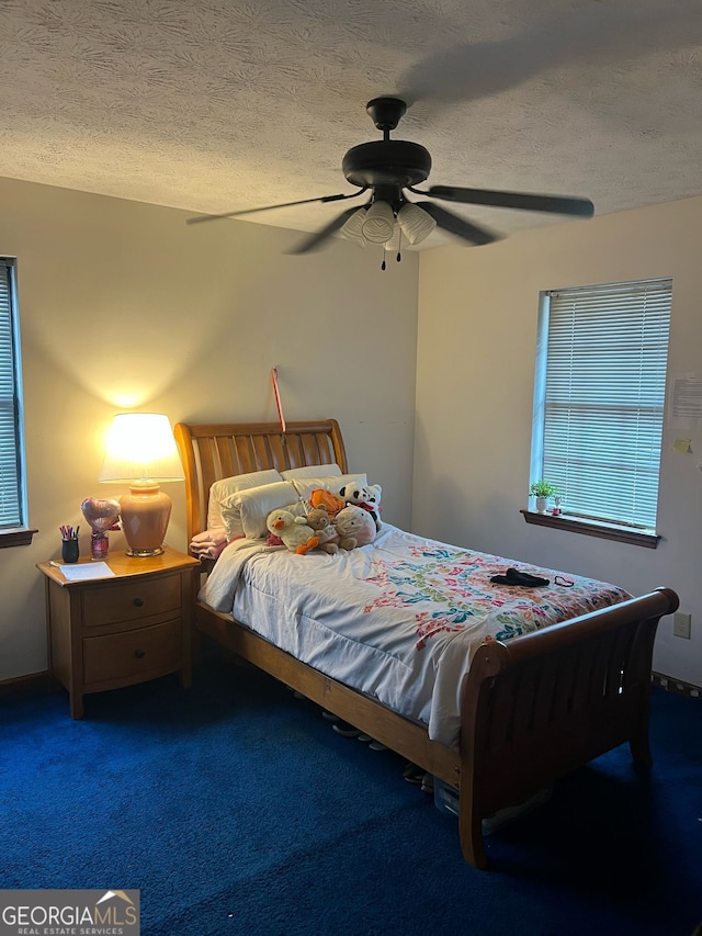 bedroom featuring a ceiling fan, a textured ceiling, and carpet flooring