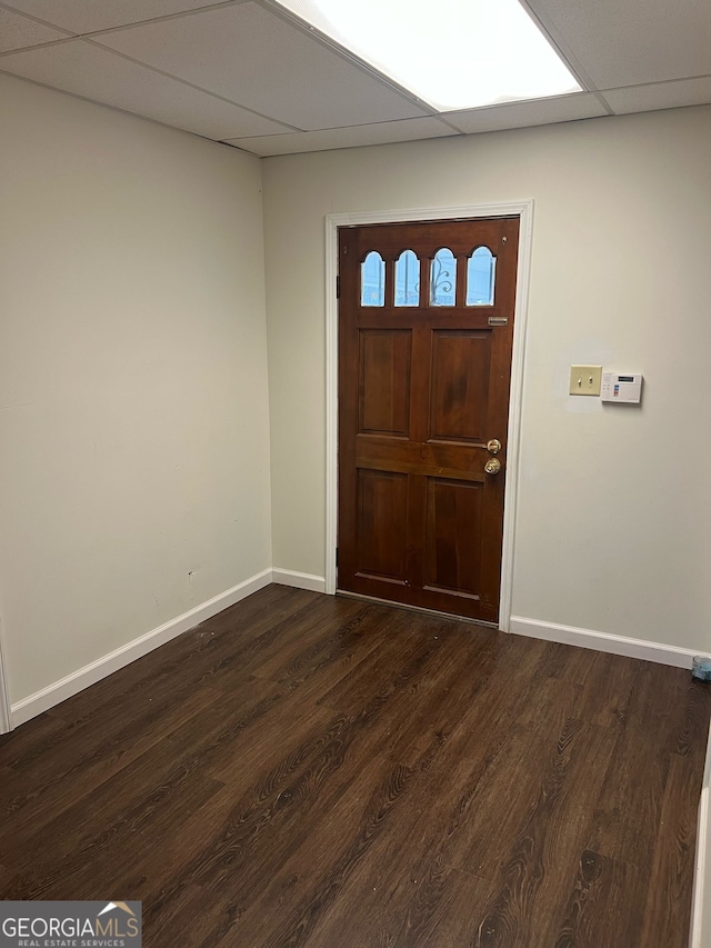 foyer entrance featuring dark wood finished floors, a paneled ceiling, and baseboards