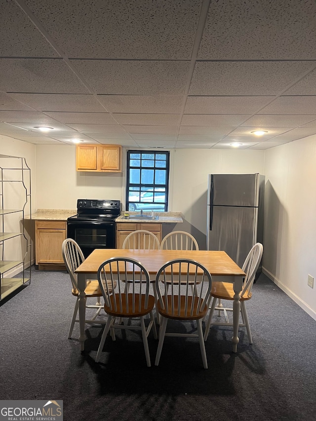 dining room featuring baseboards, a paneled ceiling, and dark carpet