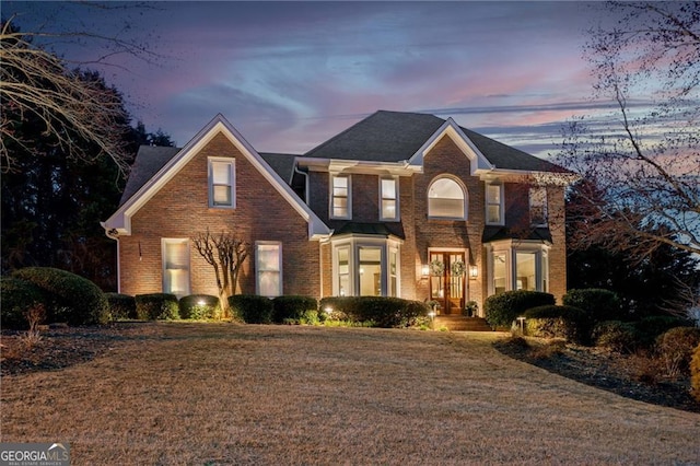 view of front facade with a front yard and brick siding