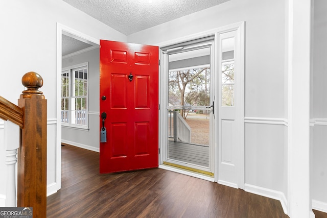 entryway with baseboards, a textured ceiling, a healthy amount of sunlight, and wood finished floors