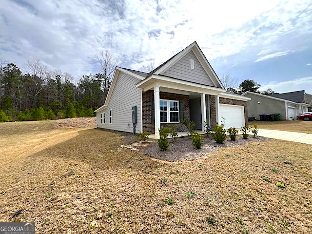 view of front of property featuring brick siding, an attached garage, and concrete driveway