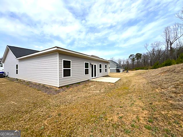 back of property with a patio and a lawn