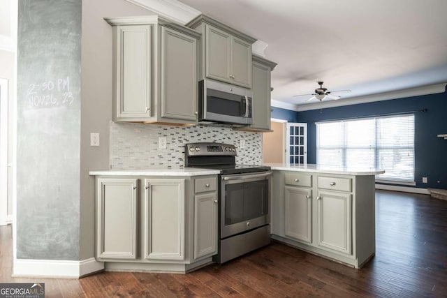 kitchen featuring gray cabinets, dark wood finished floors, appliances with stainless steel finishes, a peninsula, and light countertops