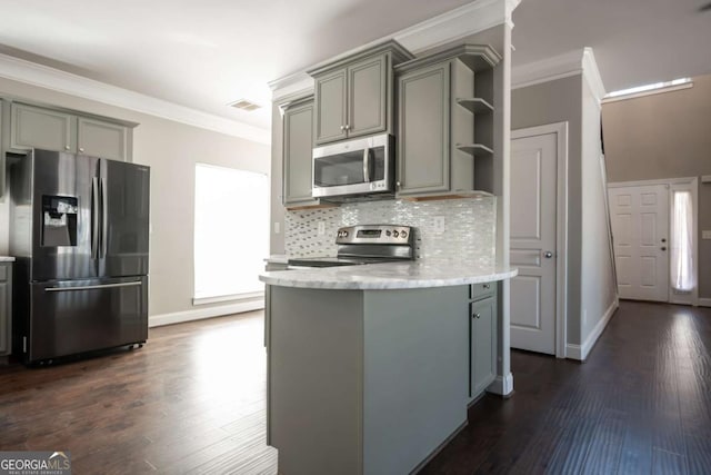 kitchen with visible vents, gray cabinets, stainless steel appliances, crown molding, and decorative backsplash