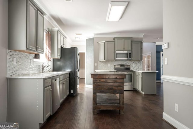 kitchen featuring a kitchen island, appliances with stainless steel finishes, gray cabinetry, and light countertops