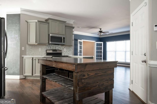 kitchen with dark wood finished floors, ornamental molding, gray cabinets, and stainless steel appliances