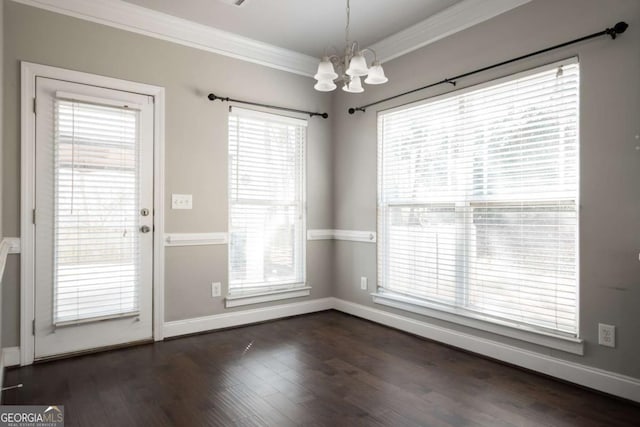 unfurnished dining area with baseboards, a chandelier, dark wood finished floors, and ornamental molding