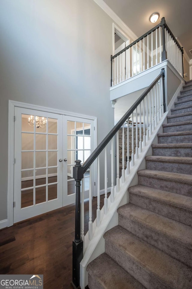 stairs featuring a high ceiling and wood finished floors