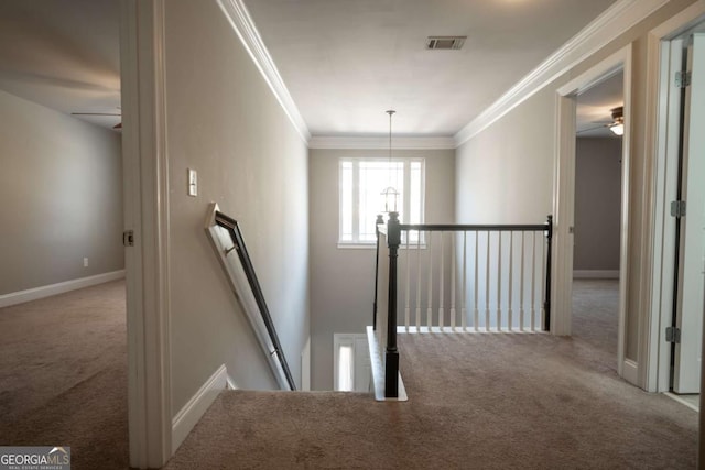 hallway featuring visible vents, an upstairs landing, ornamental molding, carpet, and baseboards