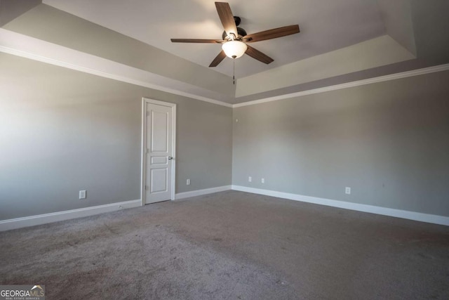 unfurnished room with baseboards, a raised ceiling, and carpet floors