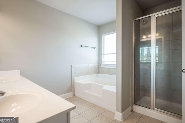 bathroom featuring a garden tub, a sink, a shower stall, tile patterned flooring, and double vanity