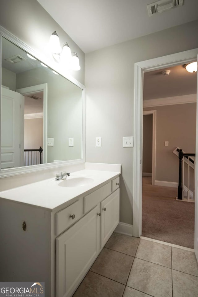 bathroom featuring vanity, baseboards, visible vents, crown molding, and tile patterned floors