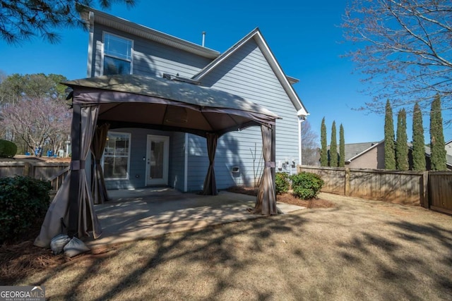 rear view of house featuring a gazebo, a patio, and a fenced backyard