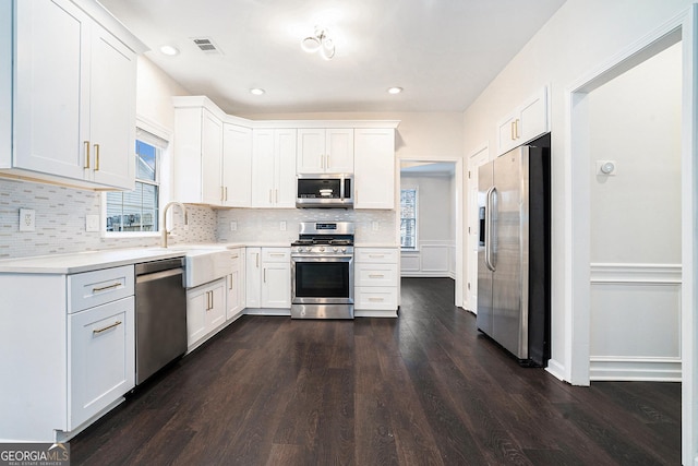 kitchen with decorative backsplash, visible vents, appliances with stainless steel finishes, and a sink