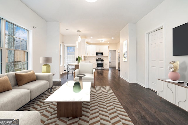 living area featuring dark wood finished floors, recessed lighting, and baseboards