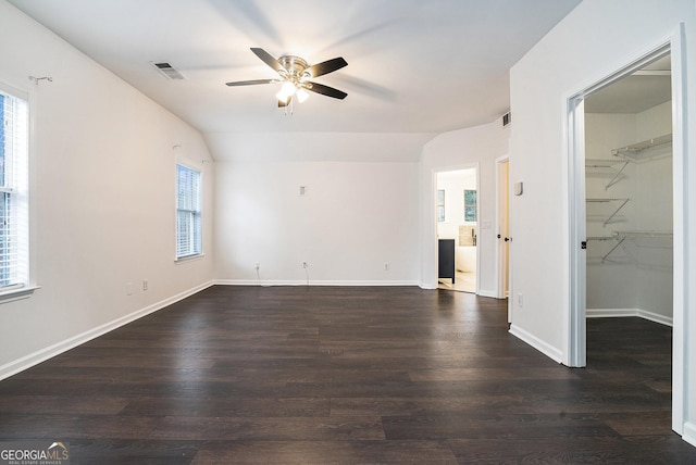 spare room with dark wood-style flooring, visible vents, a wealth of natural light, and ceiling fan