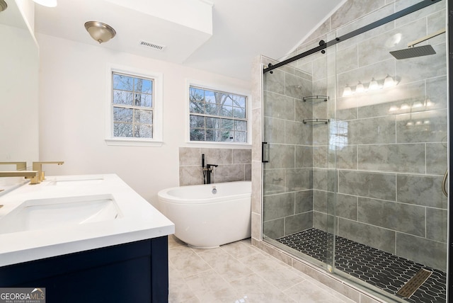 full bath featuring visible vents, a stall shower, a freestanding bath, and a sink