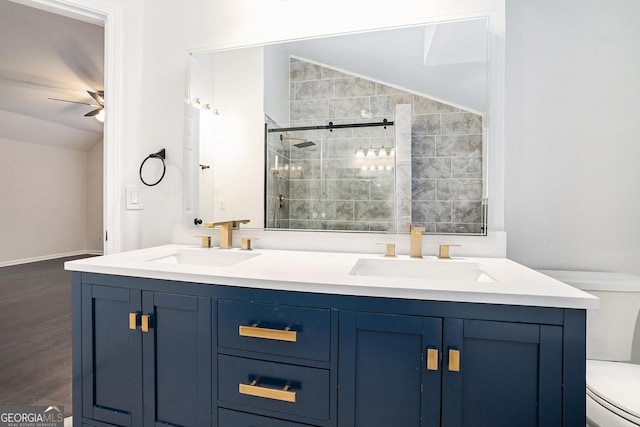 full bathroom with a sink, toilet, a shower stall, and vaulted ceiling