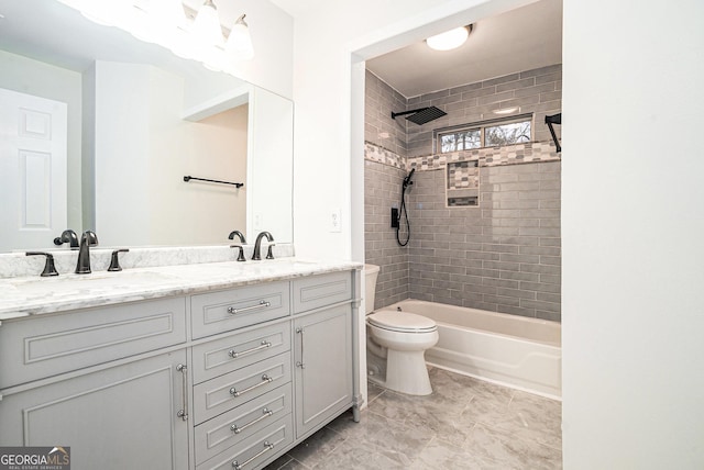 full bathroom with double vanity, tub / shower combination, toilet, and a sink