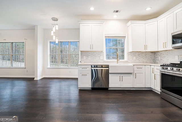 kitchen with visible vents, a sink, tasteful backsplash, stainless steel appliances, and light countertops