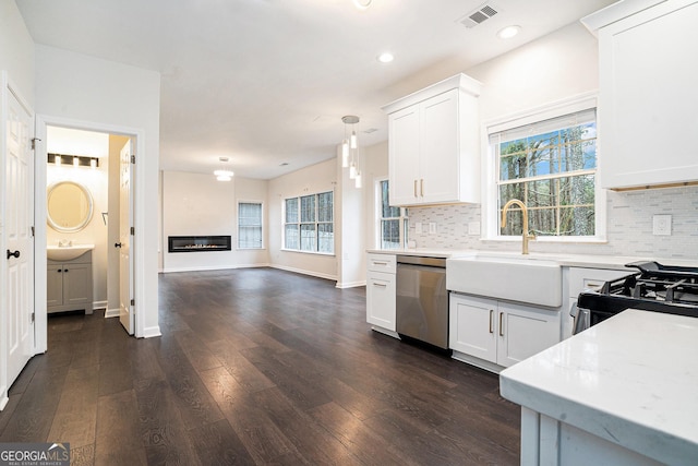 kitchen with visible vents, dark wood-style flooring, a sink, light countertops, and stainless steel dishwasher