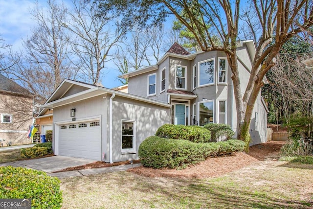 view of front of home with a garage, driveway, and stucco siding