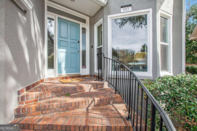 doorway to property featuring stucco siding