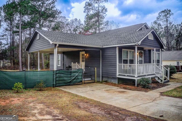 view of front of house featuring covered porch and a shingled roof