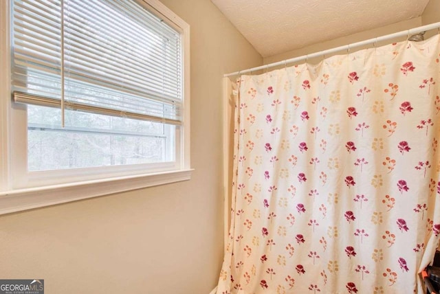 full bathroom featuring a shower with curtain and a textured ceiling