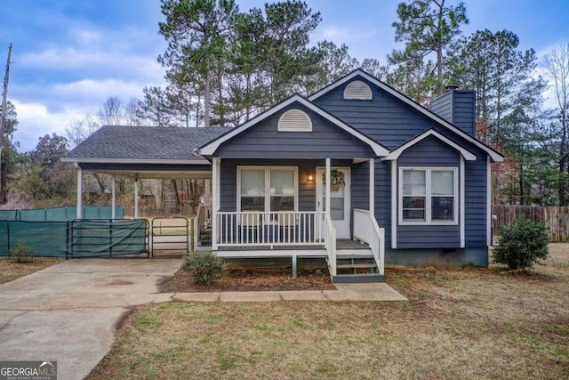 view of front of property featuring fence, a porch, concrete driveway, a chimney, and a carport