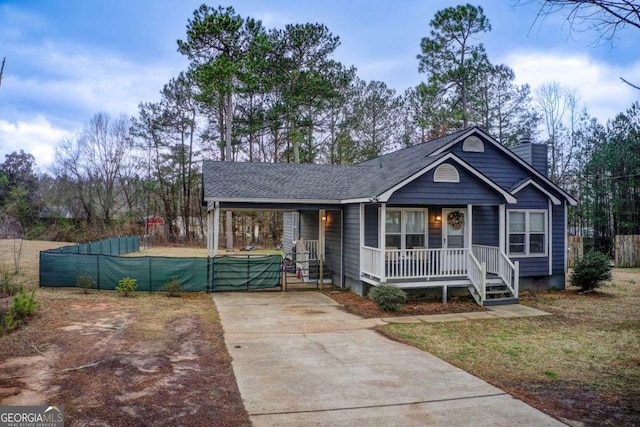 view of front of property featuring a porch, fence, and a chimney