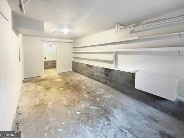 basement featuring a garage and concrete block wall