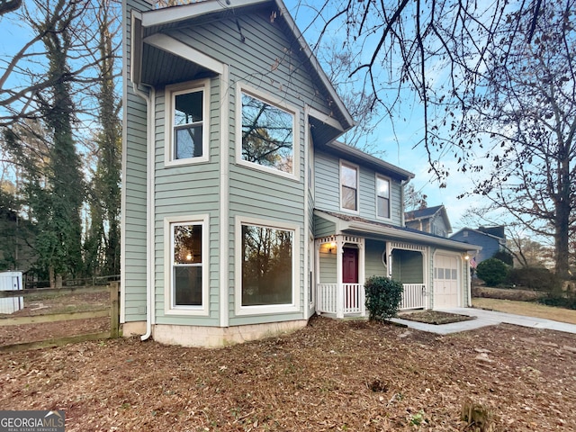 view of front of property featuring a porch, concrete driveway, and a garage