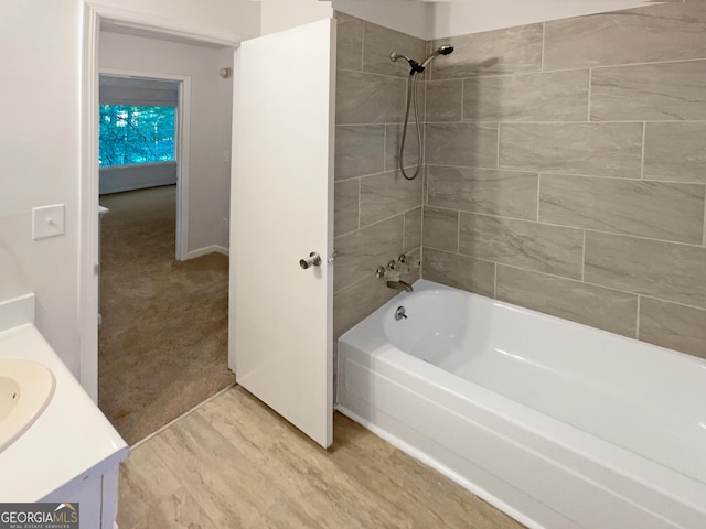 bathroom featuring vanity, wood finished floors, and washtub / shower combination